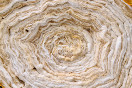 A roll of new twisted glass wool, a soft material for insulating walls and other structures, close-up, background.の写真素材
