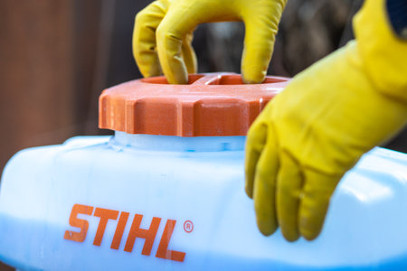 The gardeners hands in protective gloves close the lid of the tank with copper sulphate from a Stihl garden sprayer. Almaty, Kazakhstan - March 23, 2023のeditorial素材