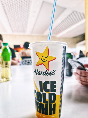 A paper cup branded Hardees stands on a table in the food court area. Almaty, Kazakhstan - July 02, 2023のeditorial素材