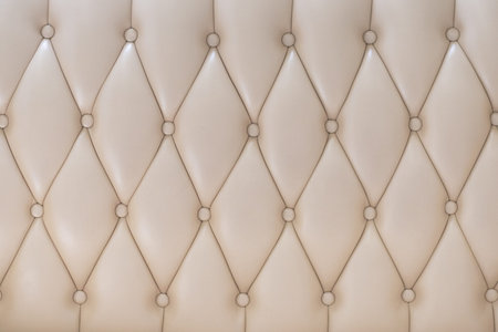 Elegant creamy beige leather upholstery texture with buttons for pattern or background.の写真素材