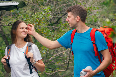A happy couple shares a joyful moment outdoors while hiking, surrounded by beautiful, lush greenery and natureの写真素材