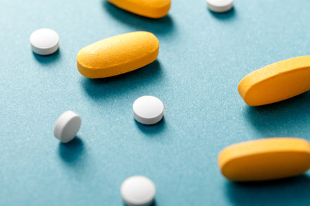 White tablets and yellow pills on a blue background.の写真素材