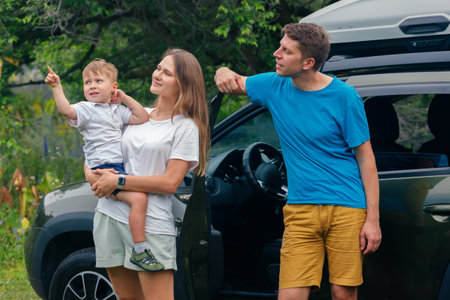 A joyful family spending quality time outdoors, pointing excitedly at natures beautiful wonders alongside their childの写真素材