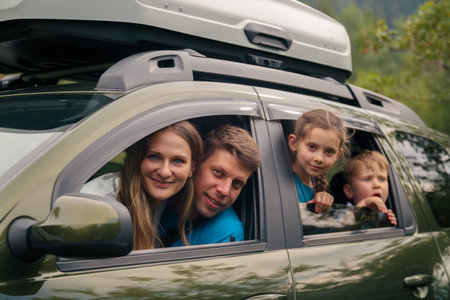 A joyful family is happily enjoying an exciting road trip in their spacious SUV surrounded by...