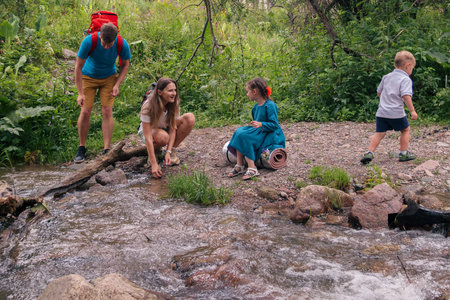 A happy family enjoys a delightful day by the peaceful stream, exploring natures beauty and bonding in joyの写真素材
