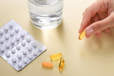 Blister pack with white tablets and yellow pills, vitamins or dietary supplements lie on the table...