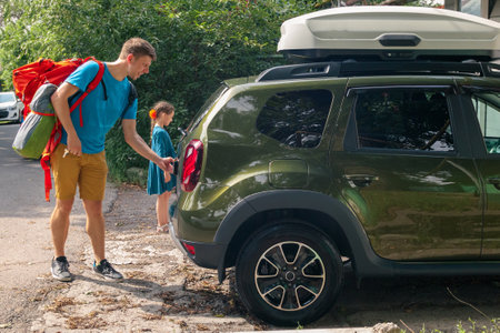 A man and a child happily loading their SUV with gear and supplies for an exciting outdoor excursion togetherの写真素材