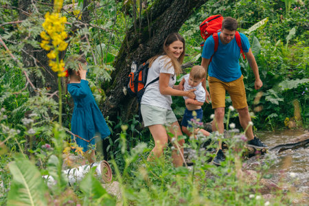 A joyful family hikes in a lush forest, creating wonderful experiences and memorable moments togetherの写真素材