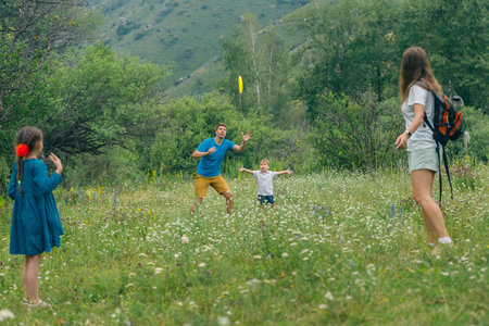 A joyful family enjoys playful moments together in a vibrant meadow filled with beautiful wildflowersの写真素材