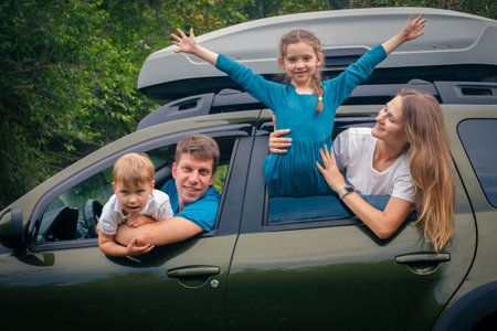 A joyful and cheerful family of four enjoying a funfilled outdoor trip together in their spacious SUVの写真素材