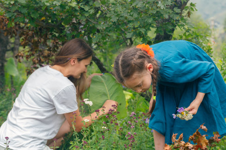 In a joyful moment in nature, children and adults gather beautiful flowers in a vibrant, colorful gardenの写真素材