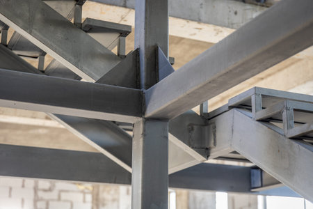 Close-up of steel beams and joints of an elevator shaft and staircase structure under construction...