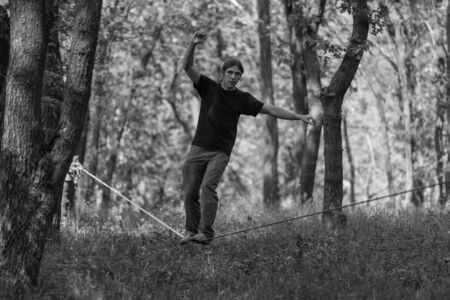 Man walking on slackline . Black and white photosの写真素材