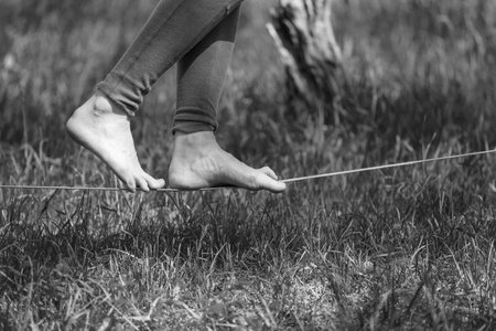 Girl walking on slackline . Black and white photos