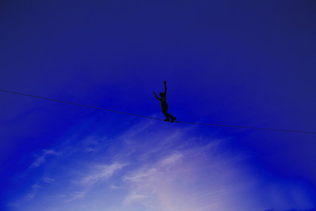 Men balancing on slackline with sky view