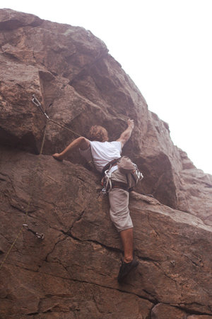 Rock climber preparing to the next move on his way