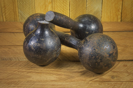 broken dumbbell on a background of wooden planksの写真素材