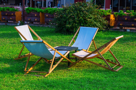 four wooden deck chairs on the grassの写真素材