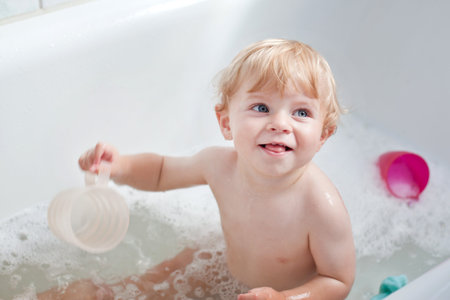 Sweet baby boy with blond hairs taking bath
