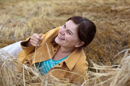 Young beautiful woman on yellow golden strawの写真素材