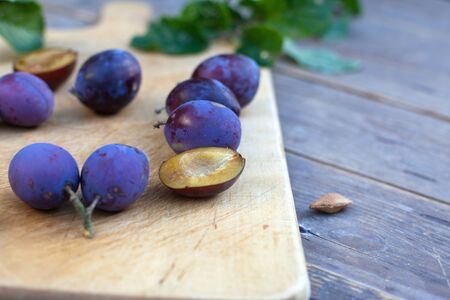 Fresh ripe blue plums on cutting boardの写真素材
