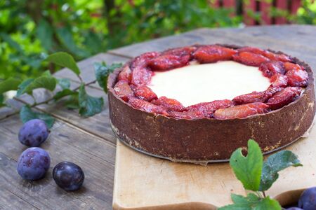 Fresh cheesecake and plums on wooden tableの写真素材
