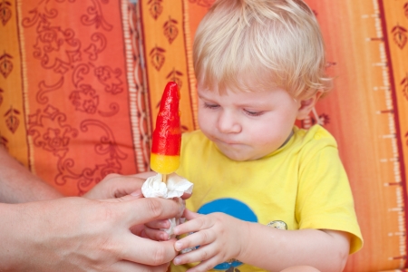 Little toddler boy eating colorful ice cream in summerの写真素材