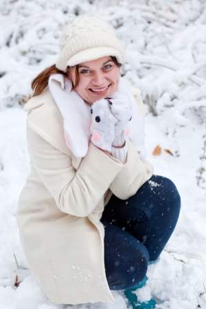 Young beautiful woman having fun with snow outdoors on beautiful winter dayの写真素材