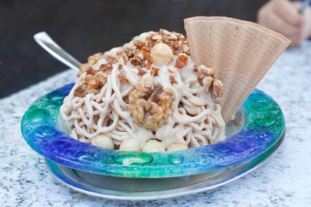 Nuts with fresh ice-cream and cream decorated with coneの写真素材
