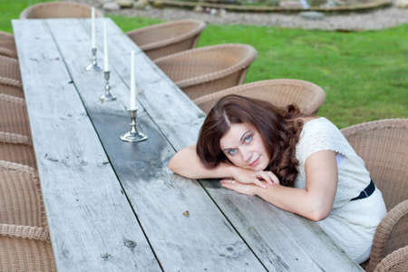 Young beautiful woman sitting in outdoor restaurant in summerの写真素材
