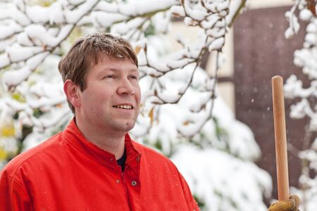 Portrait of  young man during snowfall on winter dayの写真素材