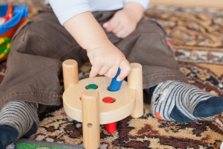 Hands of Little toddler boy playing with wooden toys indoorの写真素材