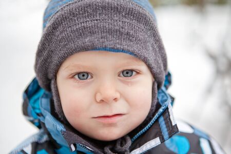 Portrait of adorable little toddler boy on winter in warm clothesの写真素材