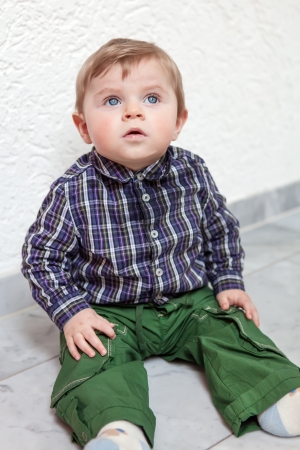 Adorable toddler with blue eyes and blond hair indoorの写真素材