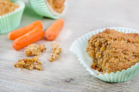 Homemade fresh baked carrot muffins with hazelnut and cinnamon on wooden backgroundの写真素材