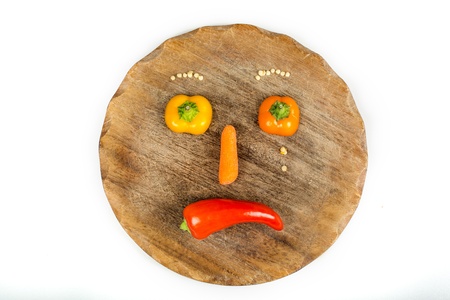 Sliced vegetables in form of a sad face with tears on white isolated backgroundの写真素材