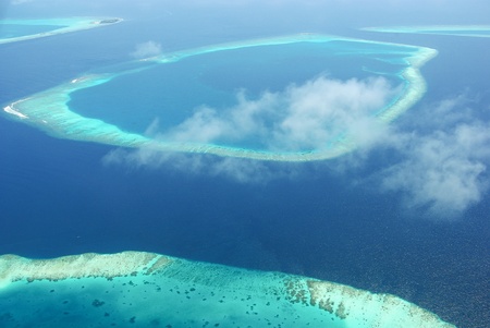 Tropical islands in Indian ocean Maldives from above with sky cloudsの写真素材