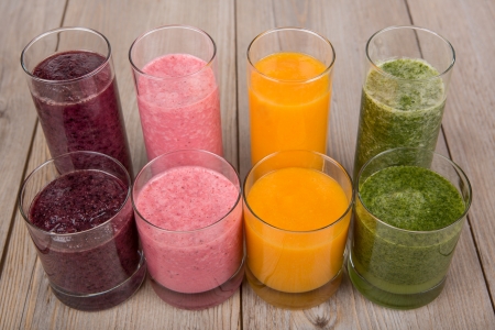 Four fruit, berry and vegetables healthy smoothies on wooden backgroundの写真素材