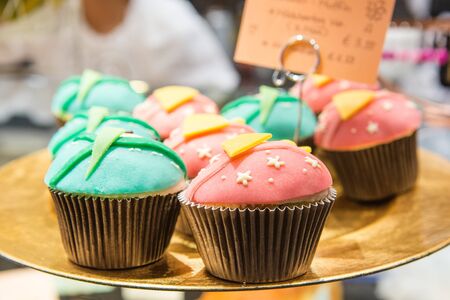 Fresh baked blue and pink cupcakes in cafeの写真素材