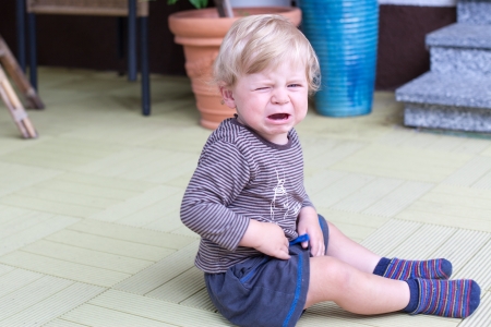 Little toddler boy crying outdoors in summerの写真素材