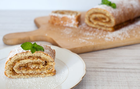 Swiss roll biscuit with pumpkin and apricot filing on wooden cutting board