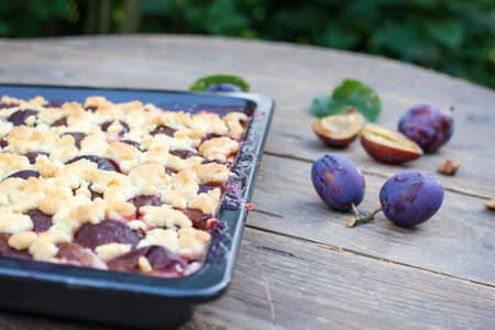 Fresh baked plum cake on wooden backgroundの写真素材