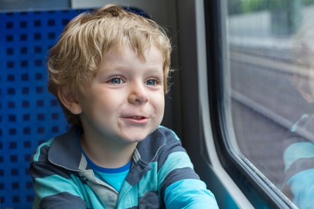 Adorable toddler boy looking out train window outside, while it moving. travelの写真素材