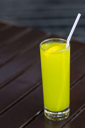 Fresh lime juice with straw on wood table in summerの写真素材