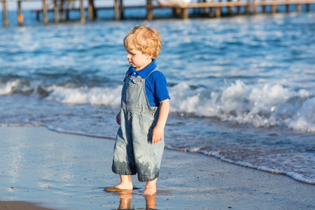 Little toddler boy having fun on the beach in summer, vacationsの写真素材