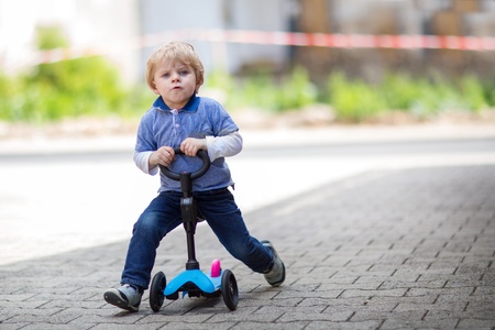 2 years old toddler boy having fun on bicycle in summerの写真素材