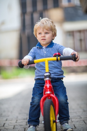 Adorable little boy having fun on bike in summerの写真素材
