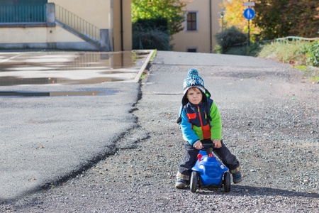 Little boy playing with toy car, outdoors, autumnの写真素材