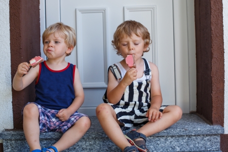 Two little sibling boys eating ice creamの写真素材