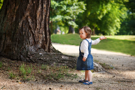 Little cute baby girl playing in summer park